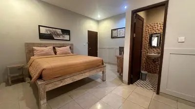 a bedroom with a bed and a bathroom with a sink at Taman Giri House 3 Bedrooms Nusa Dua in Nusa Dua