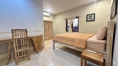 a bedroom with a bed and a desk and a chair at Taman Giri House 3 Bedrooms Nusa Dua in Nusa Dua