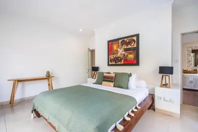 a bedroom with a large bed with a green blanket at Zen Villas by iBali Management in Kerobokan