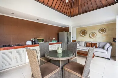 a kitchen and living room with a table and chairs at Zen Villas by iBali Management in Kerobokan