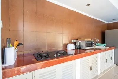 a kitchen with a stove and a microwave at Zen Villas by iBali Management in Kerobokan