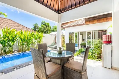 a patio with a table and chairs and a pool at Zen Villas by iBali Management in Kerobokan
