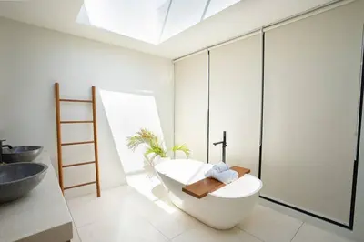 a bathroom with a white tub and a sink at Green Jimbaran Bay Villa III in Jimbaran