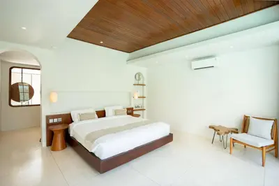 a bedroom with a large bed and a wooden ceiling at Green Jimbaran Bay Villa III in Jimbaran