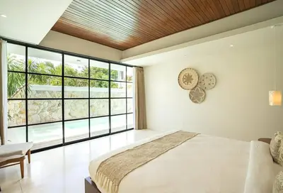 a bedroom with a large bed and a large window at Green Jimbaran Bay Villa III in Jimbaran