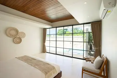 a bedroom with a bed and a large window at Green Jimbaran Bay Villa III in Jimbaran
