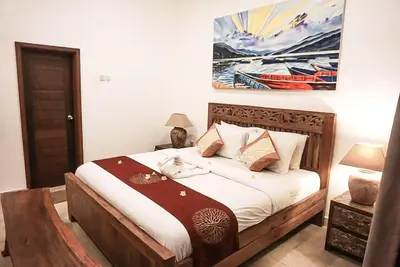 a bedroom with a bed and a painting on the wall at Seminyak Beach Villa Ashira SUPERB Location in Seminyak