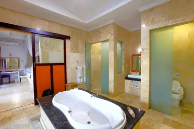 a large bathroom with a tub and a toilet at Lavender Private Villa Kuta Bali in Kuta