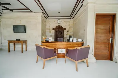 a room with a table and two chairs and a clock at You Suite Seminyak in Legian