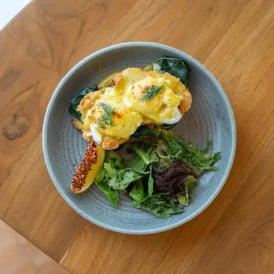 a bowl of food with a salad on a table at You Suite Seminyak in Legian