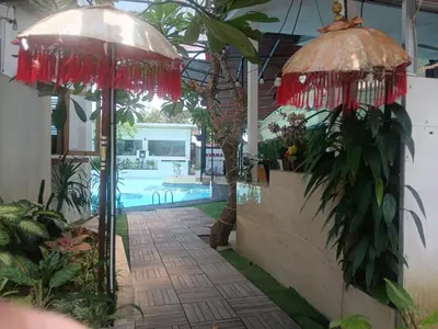 a patio with two umbrellas and a swimming pool at Villa Pool Private and Romantic In Kuta Bali in Kuta
