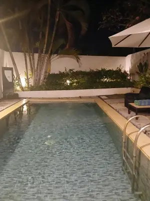 a swimming pool in a resort at night at Villa Pool Private and Romantic In Kuta Bali in Kuta