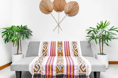 a living room with a couch and two potted plants at Villa Felicia Canggu By Moria in Canggu