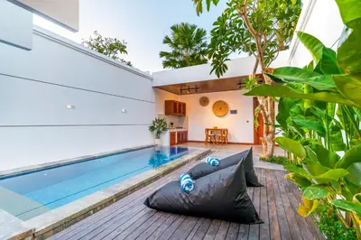 an indoor swimming pool with a swimming float next to a house at Villa Felicia Canggu By Moria in Canggu
