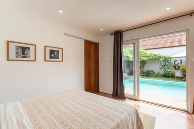 a bedroom with a bed and a swimming pool at Villa Santai pour 4 personnes à Seminyak in Seminyak