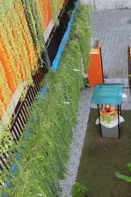 a garden with grass and a blue table next to a wall at Rena Segara House Kuta in Kuta