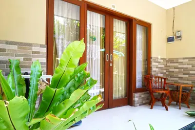 a porch with a door and a plant at Rena Segara House Kuta in Kuta