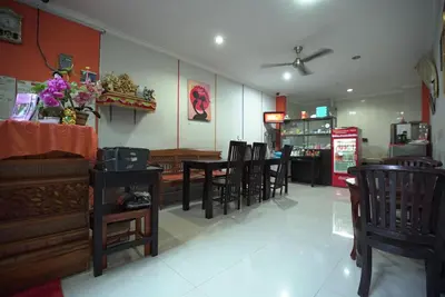 a dining room with tables and chairs and a store at Rena Segara House Kuta in Kuta