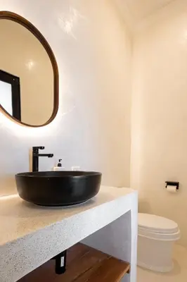 a bathroom with a black sink and a mirror at Casa De La Vida in Legian