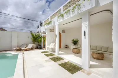 an outdoor patio with a pool and a house at Casa De La Vida in Legian