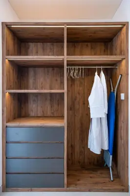 a closet with wooden walls and wooden shelves at Serai Villa by Betterplace in Seminyak