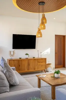 a living room with a couch and a tv at Serai Villa by Betterplace in Seminyak