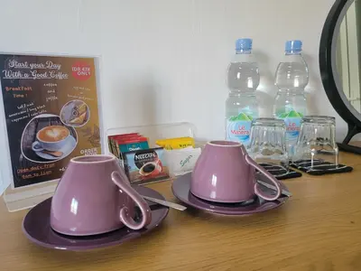a table with two pink cups and bottles of water at 9 Residences Seminyak in Seminyak