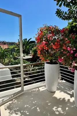a large white vase with flowers on a balcony at 450 квадратных метров, Вид на Рисовое Поле и Лес in Kerobokan