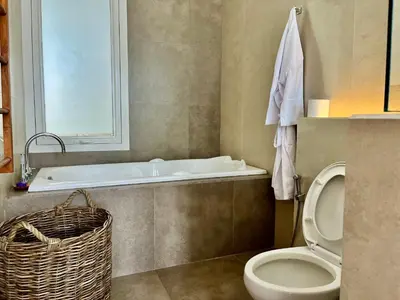 a bathroom with a tub and a toilet and a sink at 450 квадратных метров, Вид на Рисовое Поле и Лес in Kerobokan