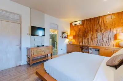 a bedroom with a bed and a flat screen tv at Villa Bella Vista by Pertama Management in Seminyak