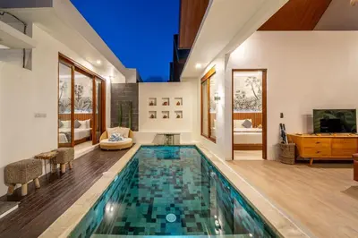 a swimming pool in a house with a living room at Umasuka Villa in Denpasar