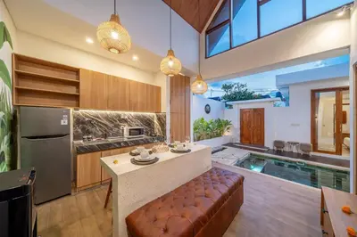 a kitchen with a couch and a kitchen with a pool at Umasuka Villa in Denpasar