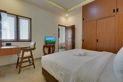 a bedroom with a bed and a desk and a computer at Villa Taman Seminyak 46 Near Double Six Beach in Seminyak