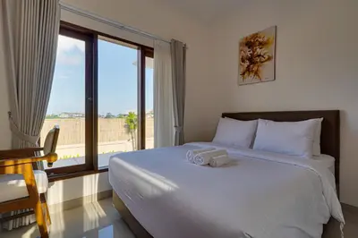 a bedroom with a large bed and a large window at Villa Taman Seminyak 46 Near Double Six Beach in Seminyak