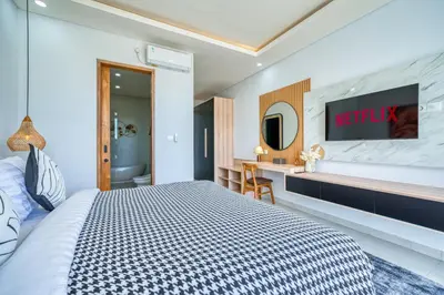 a hotel room with a bed and a tv on a wall at Villa Kangla - 3BR Luxurious Villa Seminyak in Seminyak