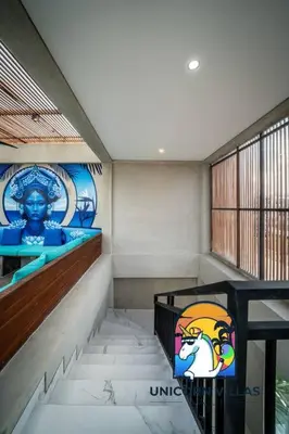 a staircase in a building with a painting on the wall at SOHO Seminyak 1 - by Unicorn Villas Bali in Seminyak