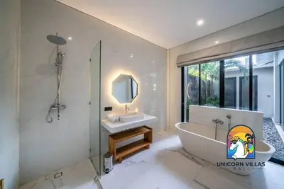 a bathroom with a tub and a sink and a mirror at SOHO Seminyak 1 - by Unicorn Villas Bali in Seminyak