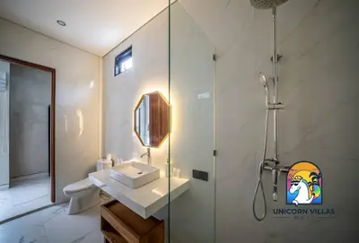 a bathroom with a glass shower and a sink at SOHO Seminyak 2 - by Unicorn Villas Bali in Seminyak