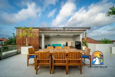 a wooden table and chairs on a patio at SOHO Seminyak 2 - by Unicorn Villas Bali in Seminyak