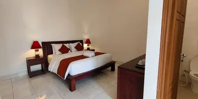 a bedroom with a bed and a bathroom with a toilet at Kusuma Homestay Kerobokan in Kerobokan