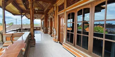 a large building with large windows and a balcony at Kusuma Homestay Kerobokan in Kerobokan