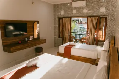 a hotel room with two beds and a television at Dara House in Kuta