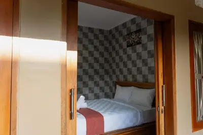 a bedroom with a bed with a checkerboard wall at Dara House in Kuta