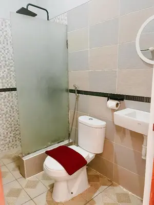 a bathroom with a toilet and a shower and a sink at Dara House in Kuta