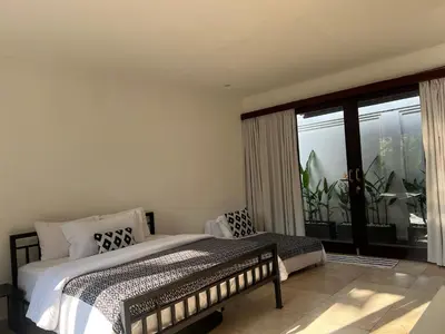 a bedroom with a bed and a large window at The Mia Bali in Kerobokan