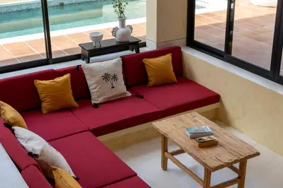 a red couch in a living room with a table at Villa Casa Del Sol Umalas in Kerobokan