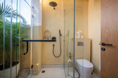 a bathroom with a shower with a toilet and a glass door at Villa Casa Del Sol Umalas in Kerobokan