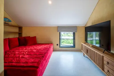 a living room with a red couch and a flat screen tv at Villa Casa Del Sol Umalas in Kerobokan