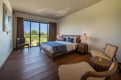 a bedroom with a bed and a large window at Villa Charleston Umalas in Kerobokan