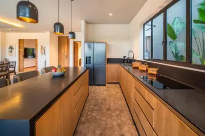 a kitchen with a large counter and a refrigerator at Villa Charleston Umalas in Kerobokan